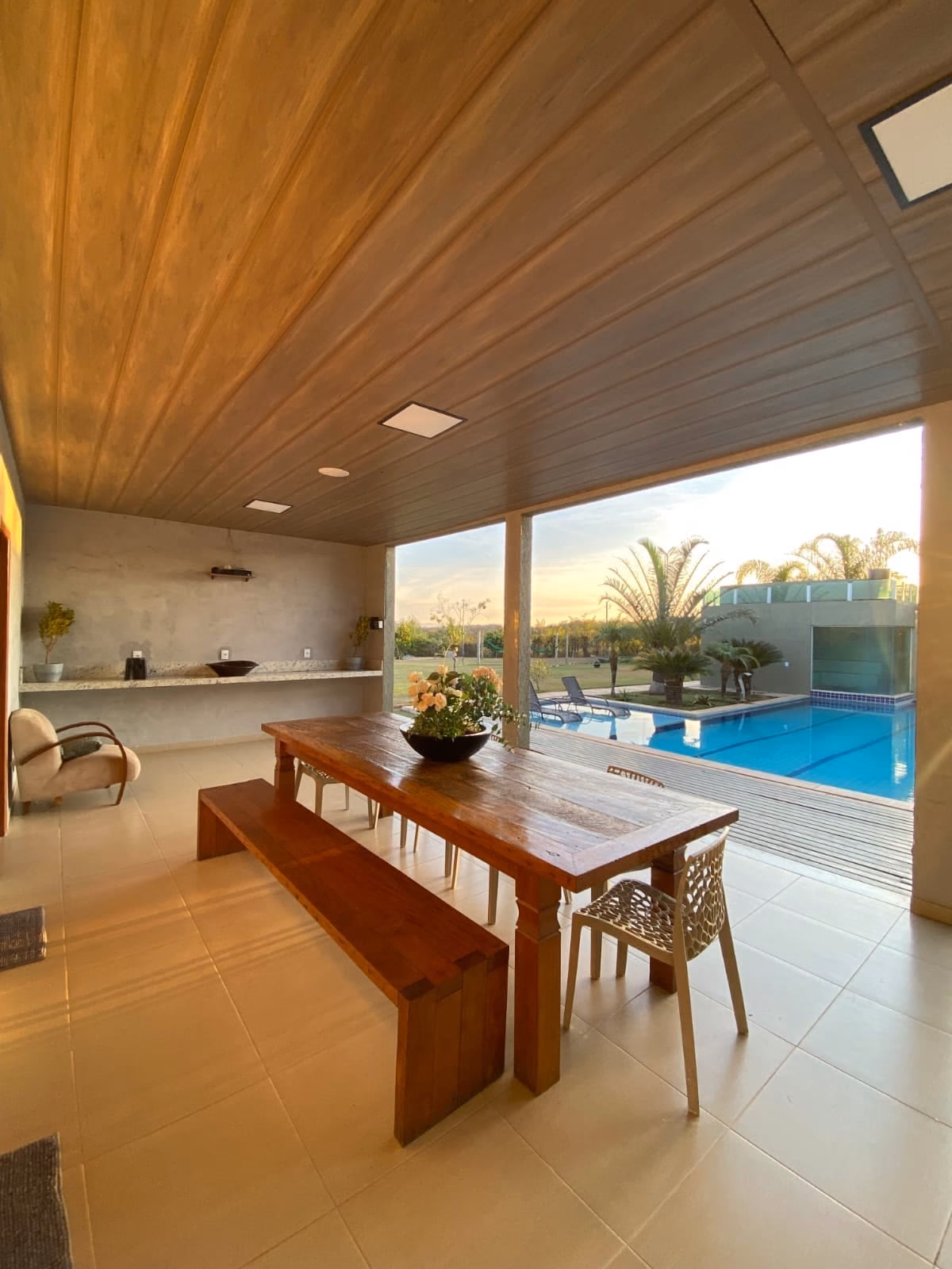 Bancada da área gourmet com vista para a piscina ao entardecer