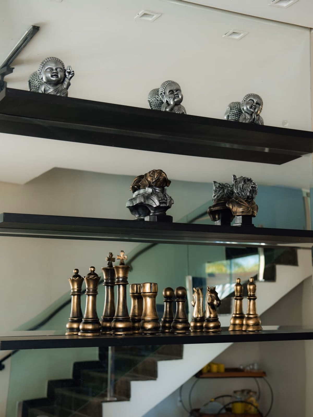 Escada com prateleiras de vidro decoradas com peças de coleção