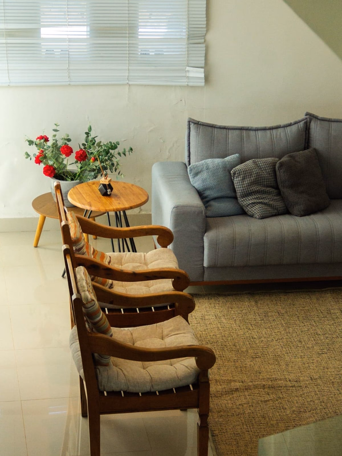 Sala de estar com arranjo de flores e poltronas de madeira