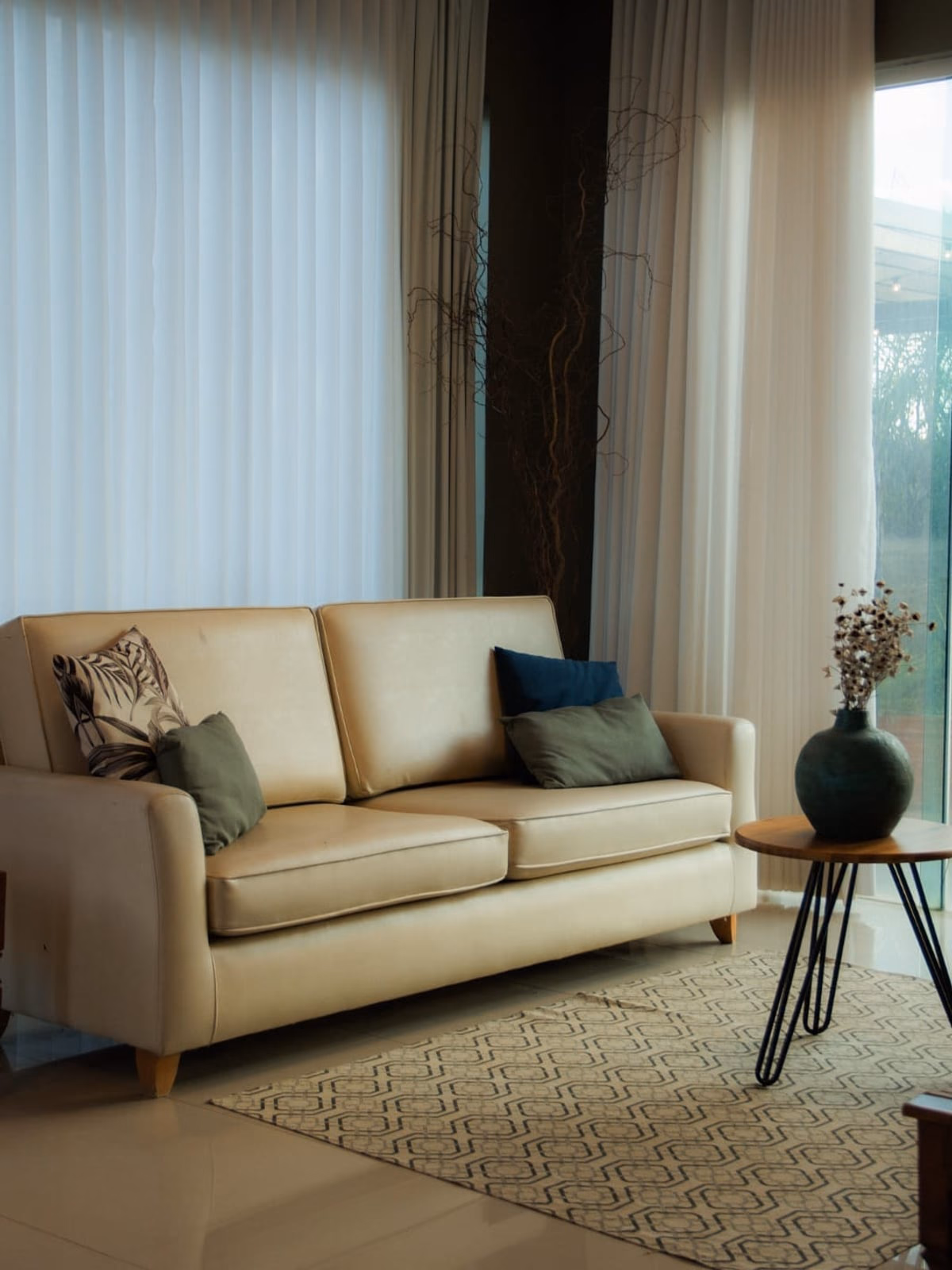 Sala de estar com sofá bege e cortinas longas