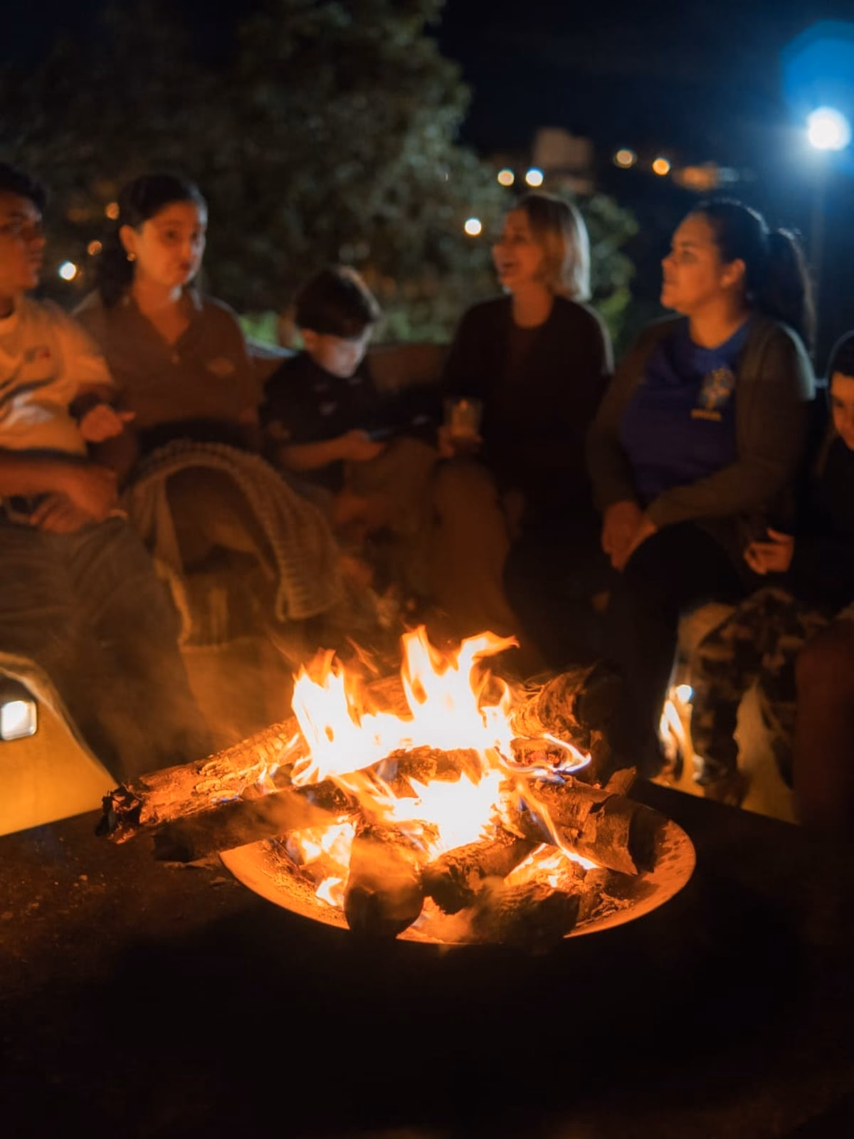 Grupo reunido ao redor da fogueira, à noite