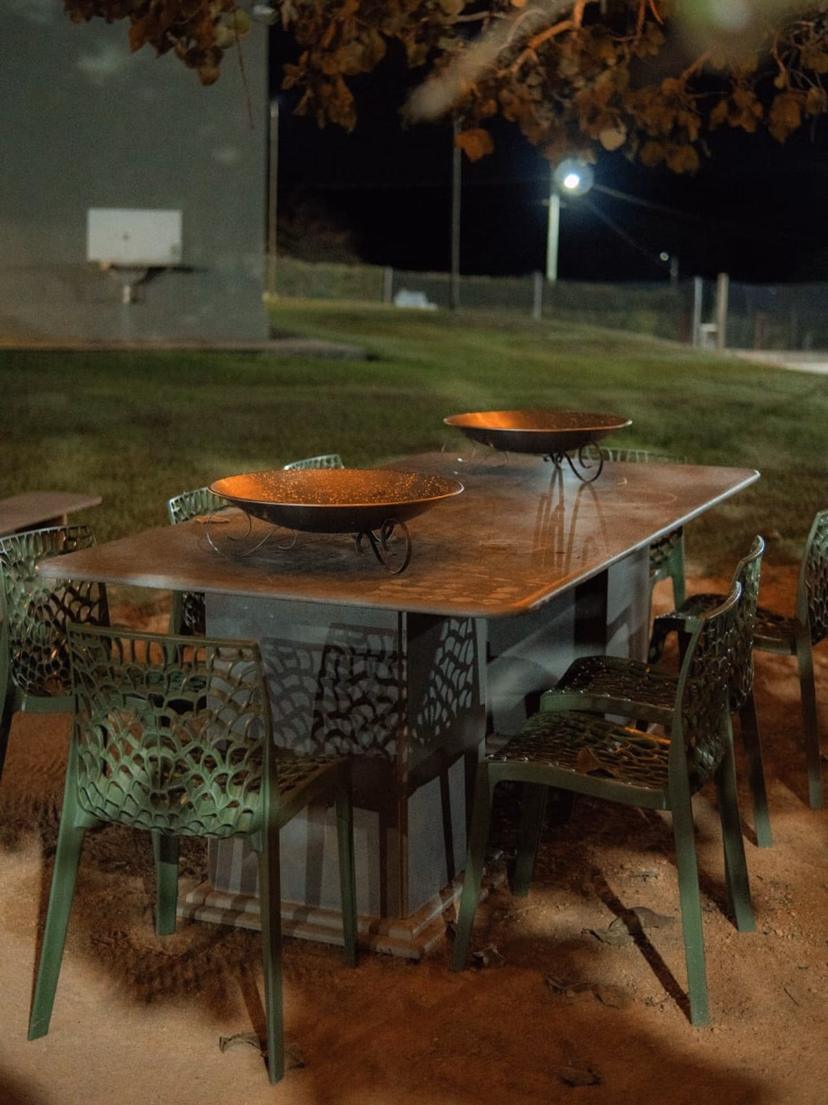Mesa externa com braseiros decorativos ao anoitecer