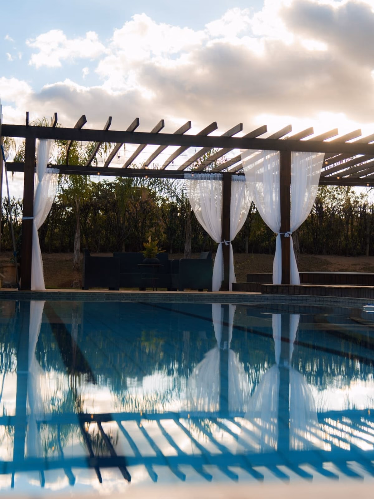 Piscina e hidromassagem com reflexo do céu nublado