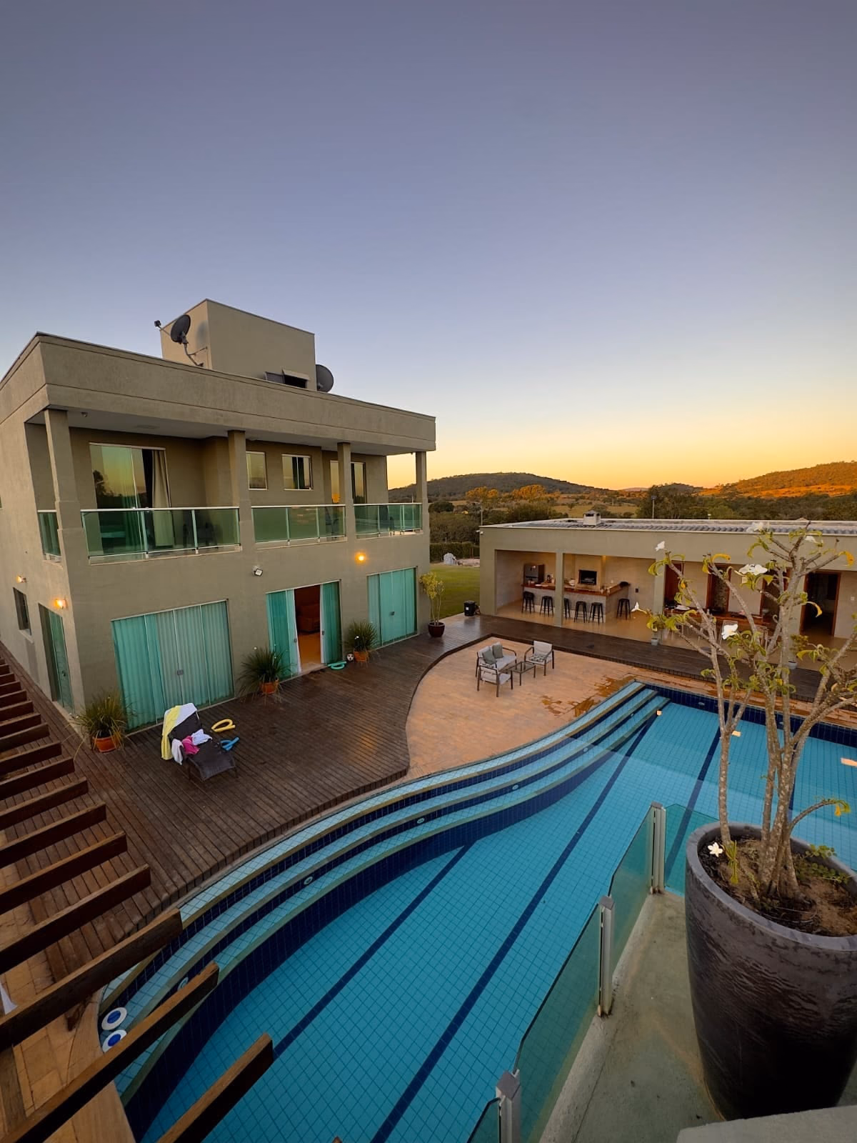 Vista aérea da casa e da piscina ao entardecer