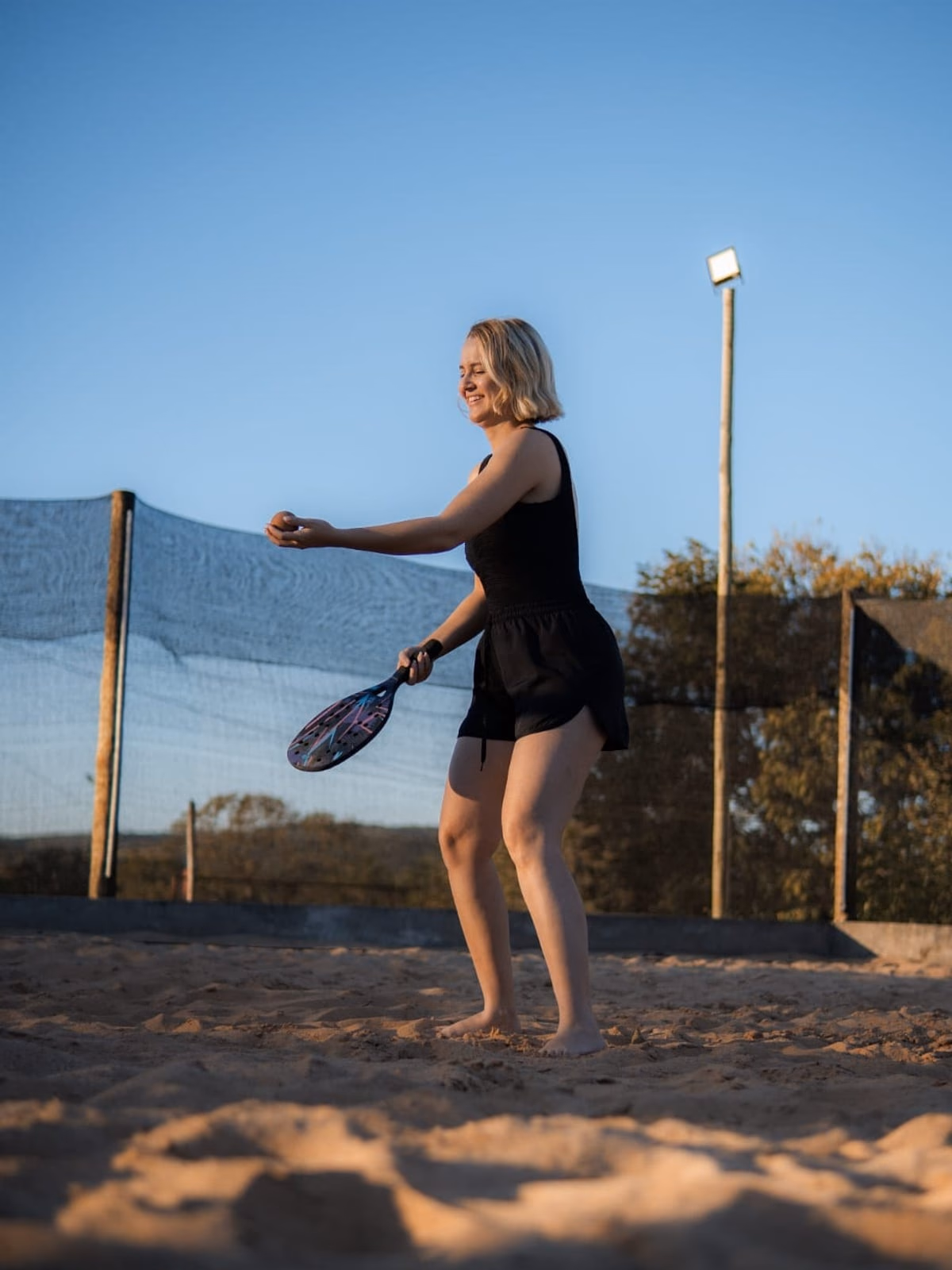 Hóspede jogando beach tennis na quadra de areia