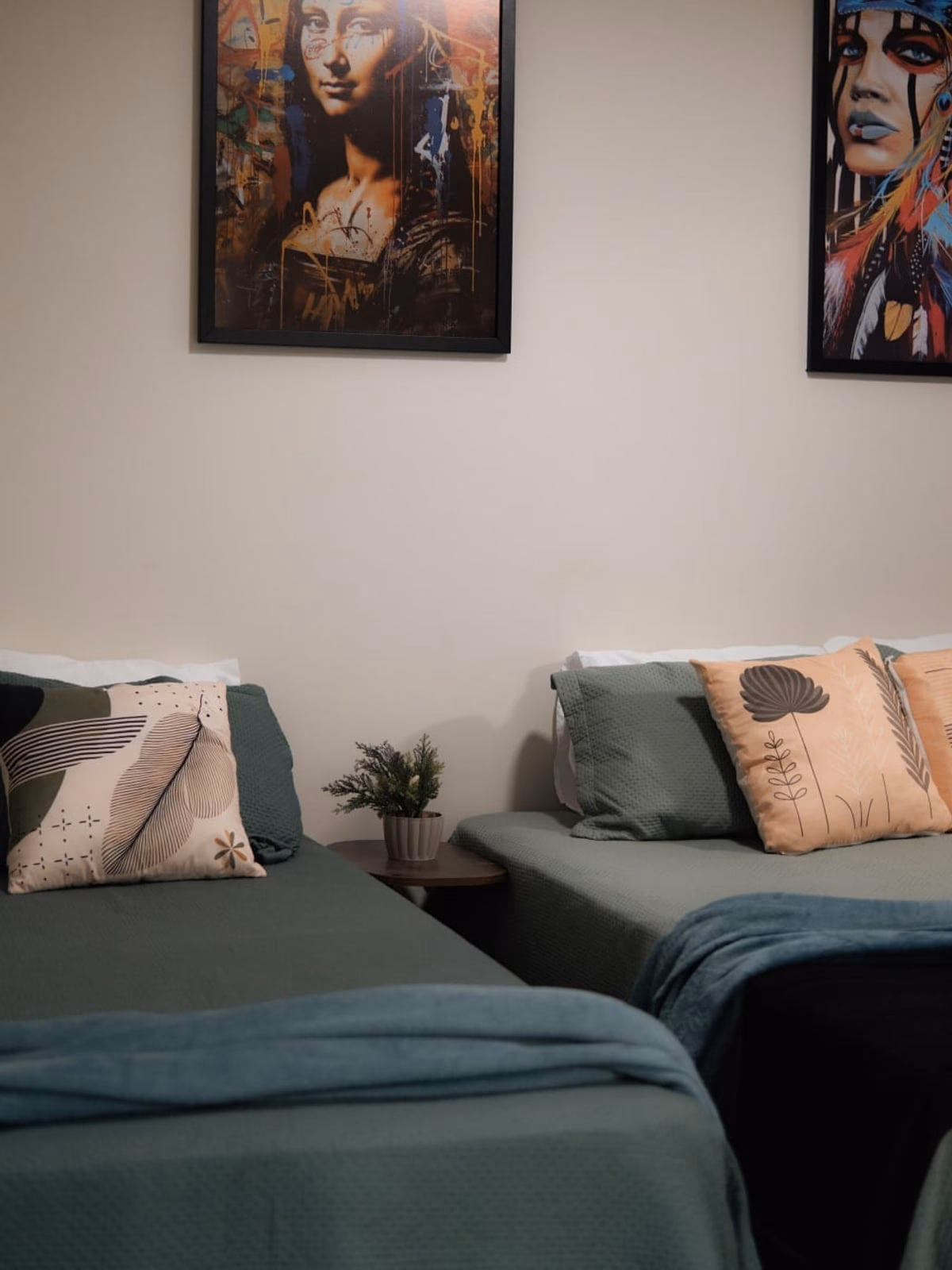 Quarto com duas camas de solteiro e quadro inspirado na Mona Lisa