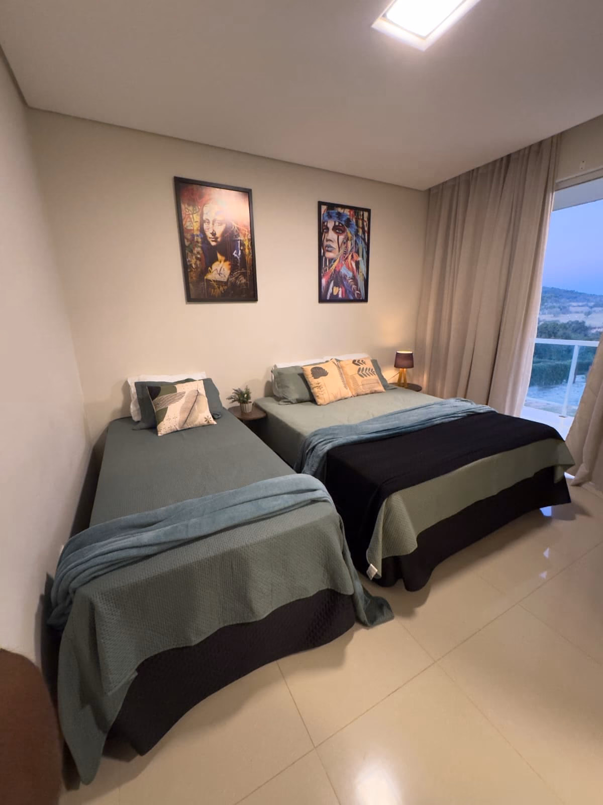 Quarto com camas de solteiro e quadros de arte pop na parede