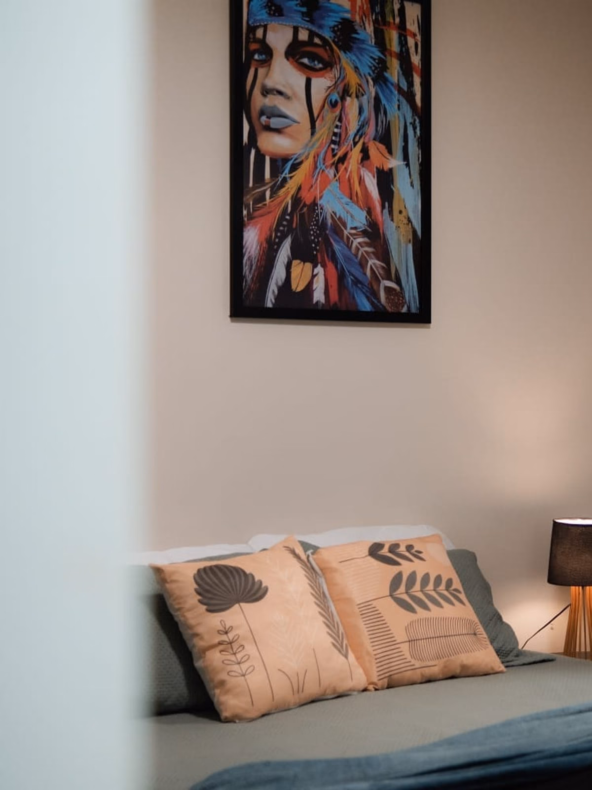Detalhe de cabeceira com abajur e quadro na parede